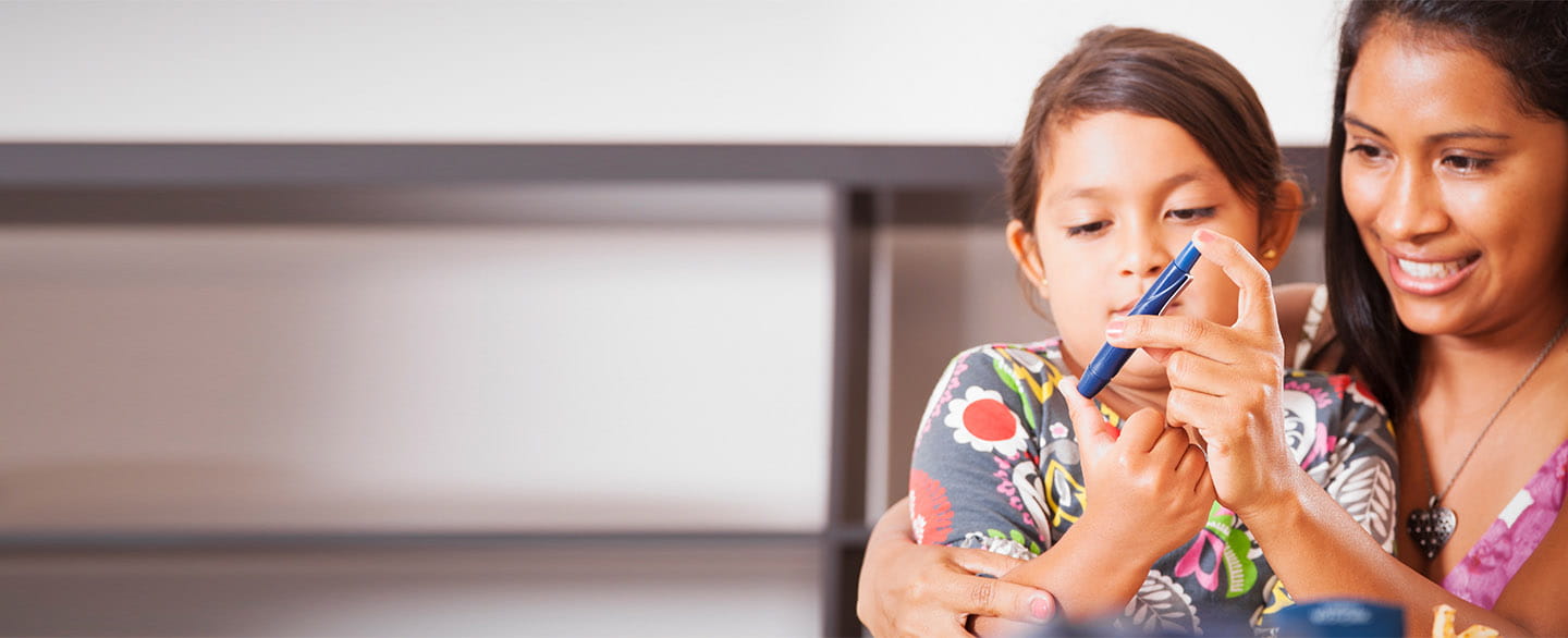 Mom checking her daughter's blood sugar.