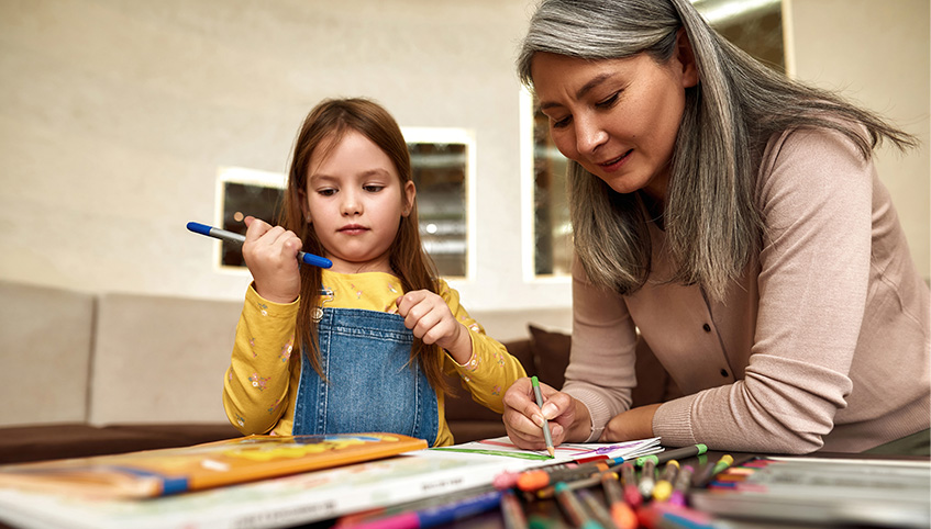 A woman and a child drawing together